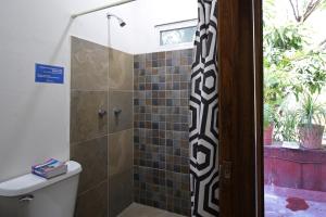 ein Bad mit einer Dusche und einer Glastür in der Unterkunft Hostel Hospedarte Chapultepec in Guadalajara