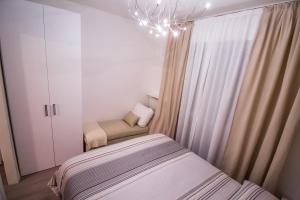 a small bedroom with a bed and a chandelier at Casa Clara in Altavilla Vicentina