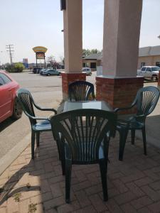 two chairs and a table on a sidewalk at Super 8 by Wyndham Moose Jaw SK in Moose Jaw