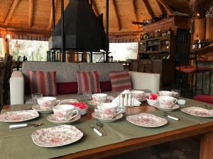 una mesa con platos y tazas encima en Los Nires Lodge Cerro Catedral en San Carlos de Bariloche