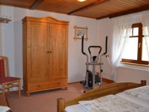 a bedroom with a wooden cabinet and a treadmill at Spreewald-Domizil in Lübbenau