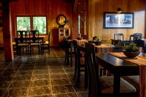 a restaurant with wooden walls and tables and chairs at Sieteflores Hosteria De Montaña in San Martín de los Andes