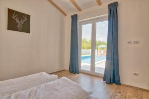 een slaapkamer met een bed en uitzicht op een zwembad bij Villa Blaise in Manjadvorci