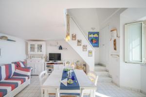 sala de estar con mesa y sofá en Corricella Sea Window - Gioia Apartments en Procida