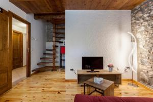 sala de estar con TV y suelo de madera en Hotel Cal Rei de Talló, en Bellver de Cerdanya 