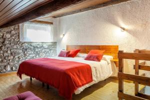 a bedroom with a large bed with red pillows at Hotel Cal rei de Talló in Bellver de Cerdanya