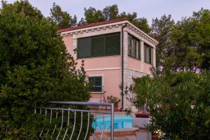 a pink house with a pool in front of it at Villa Rosada in Vela Luka +27 photos