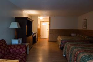 a hotel room with two beds and a couch at King Hendrick Motel and Suites in Lake George