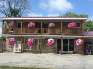 ein Haus mit rosa Blumen auf dem Balkon in der Unterkunft Northland Motel Bay City-Kawkawlin in Kawkawlin