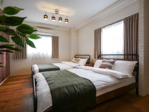 sypialnia z 2 łóżkami i oknem w obiekcie Sakura Coco Residence w Osace