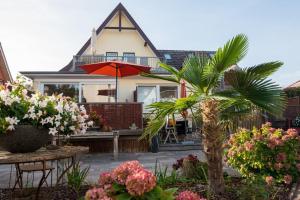 une maison avec un palmier en face dans l'établissement Altes Strandhus Casa Stranddune, à Scharbeutz