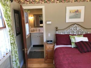 a bedroom with a bed and a bathroom with a sink at Baywick Inn Bed & Breakfast in Nelson