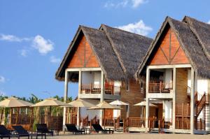 a resort with tables and chairs and umbrellas at Maalu Maalu Resort & Spa - Thema Collection in Pasikuda