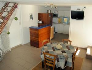 Gîte de Pont C'Hoat في نيفيز: مطبخ وغرفة طعام مع طاولة في الغرفة