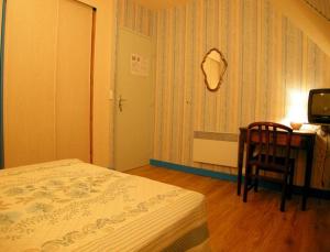 ネヴェにあるGîte de Pont C'Hoatのベッドルーム1室(ベッド1台、テーブル、椅子付)