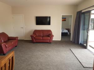 a living room with two couches and a flat screen tv at Bellhaven in Cromwell