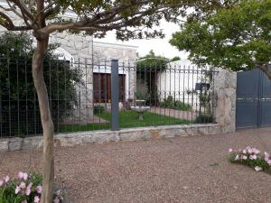 a fence in front of a house with pink flowers at Remanso Cochera opcional in Bahía Blanca