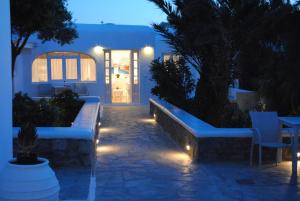 a white bench sitting in front of a pool of water at Hotel Milena in Mikonos