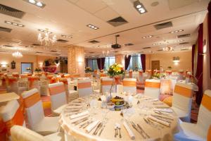 una sala banchetti con un lungo tavolo con posate di Mari Vila Hotel a Bucarest Altre 37 foto
