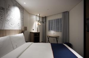 Holiday Inn Express Seoul Hongdae, an IHG Hotel في سول: غرفة في الفندق مع سرير ومكتب