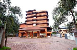 a large building with palm trees in front of it at Hotel Park Residency in Nilambūr