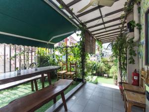 an outdoor patio with wooden benches and plants at Rain Forest Hotel in Kuala Lumpur