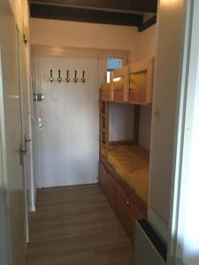 レ・ザングルにあるAppartement Cosyの二段ベッドとドアが備わる小さな客室です。