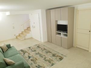 a living room with a couch and a television at Deluxe Apartments Garda in Sirmione