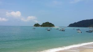 a group of boats in the water on a beach at Pangkor Bay View Beach Resort in Pangkor