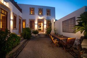 a patio with a table and chairs in front of a house at Villa Lindos in Líndos