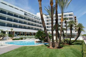 a hotel with palm trees in front of a building at RH Bayren Hotel & Spa 4* Sup in Gandía