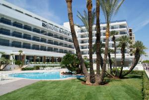 a hotel with palm trees in front of a building at RH Bayren Hotel & Spa 4* Sup in Gandía