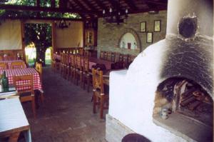 a restaurant with a fireplace in the middle of a room at Herold Panzió in Dunabogdány