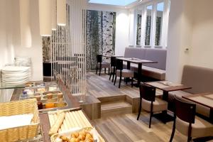 a restaurant with tables and chairs and a counter with food at Hôtel du Parc Ath in Ath