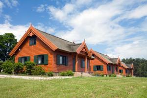 una grande casa in legno con un ampio cortile di Brzezina Resort - Wille a Żnin