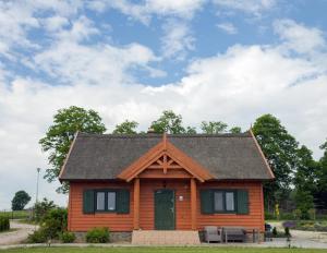 eine Blockhütte mit einem Gamerleich-Dach in der Unterkunft Brzezina Resort - Wille in Żnin