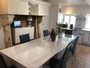a kitchen with a large white table and chairs at LES GITES DE MONTMARTRE in Le Perrier