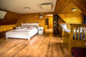 a bedroom with a white bed and wooden walls at Chalupa Přeslička in Rejvíz +34 photos