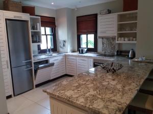 a kitchen with white cabinets and a granite counter top at Papay Suite by Simply-Seychelles in Eden Island