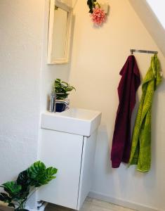 a bathroom with a white sink and a mirror at 27 Vestergade in Tønder +8 photos