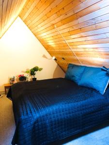 a bedroom with a blue bed with a wooden ceiling at 27 Vestergade in Tønder