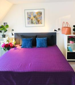 a purple bed with blue pillows in a bedroom at 27 Vestergade in Tønder