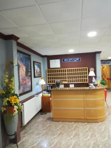 a waiting room with a reception desk and flowers at Hotel La Bolera in Vinaròs