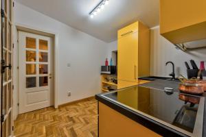 cocina con armarios amarillos y encimera negra en Le Park, en Bucarest 24 fotos más