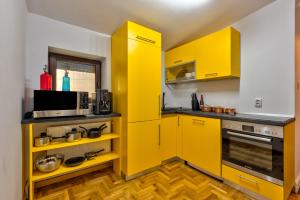 cocina con armarios amarillos y microondas en Le Park, en Bucarest