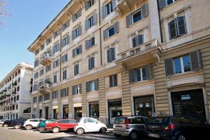 un grande edificio con macchine parcheggiate di fronte di MF Hotel a Roma