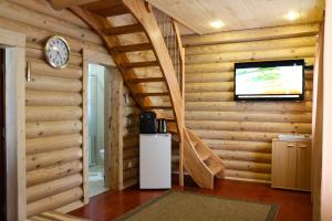 a living room with a clock and a tv at Blockhaus in Lahr