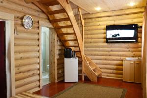 Habitación con escalera y TV en una cabaña de madera. en Blockhaus, en Lahr