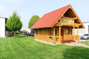 una cabaña de madera con techo rojo en un patio en Blockhaus, en Lahr