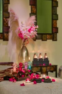 a table with a vase with pink flowers and candles at Kefaluka Resort Ultra All Inclusive in Akyarlar